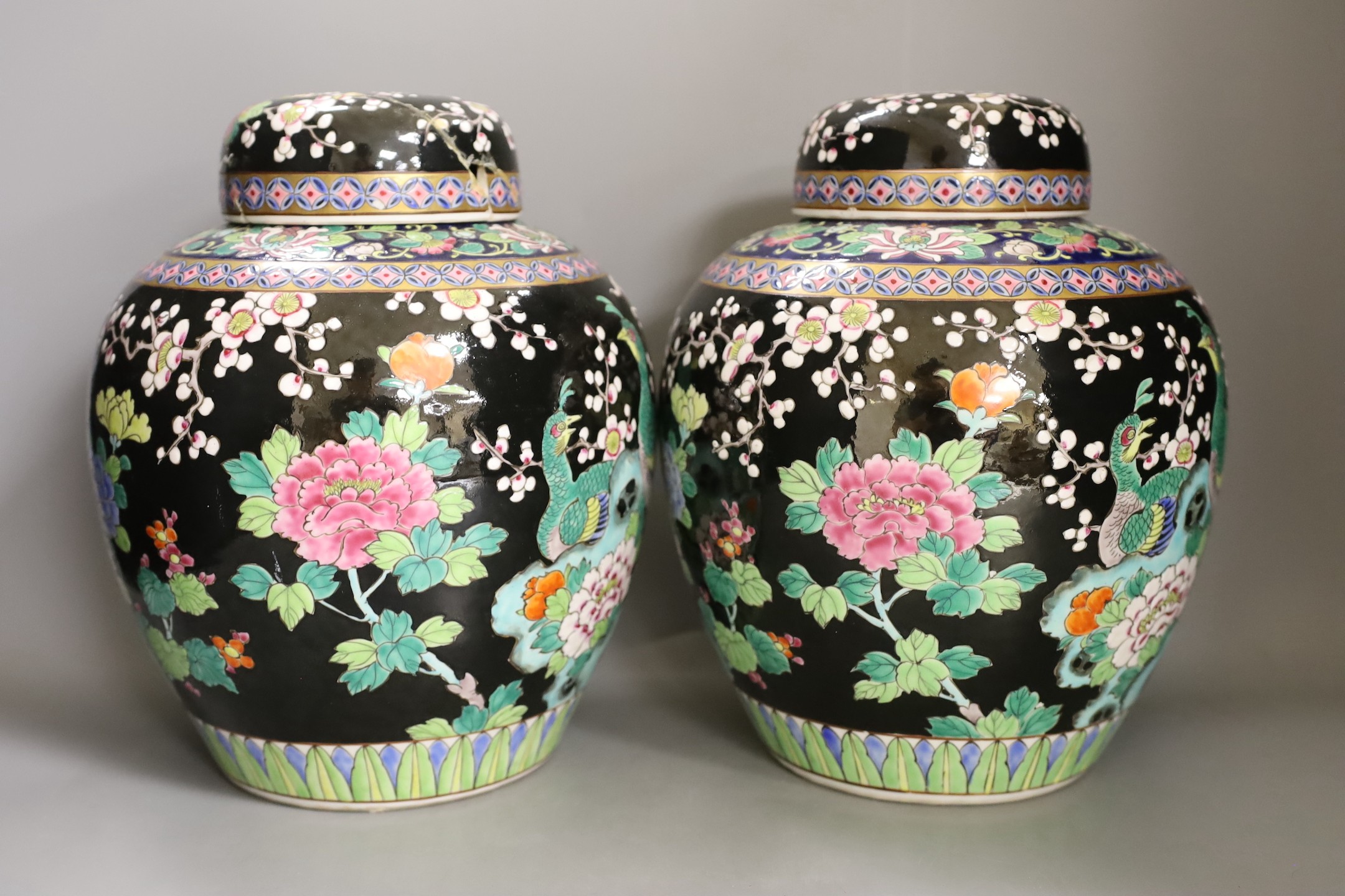 A pair of Japanese famille noire jars and covers 27cm